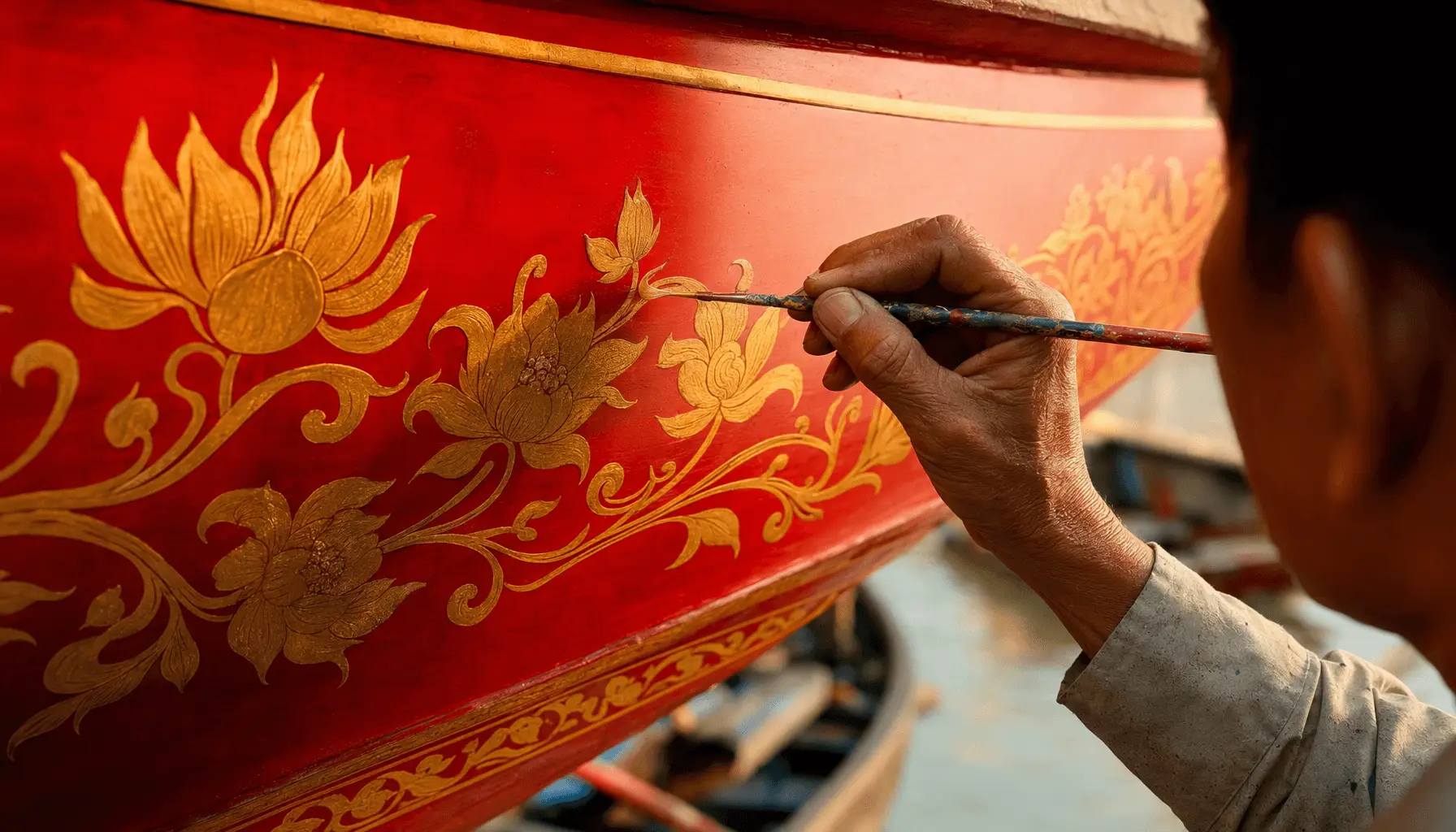 Thợ sơn vẽ hoa văn lên thân ghe